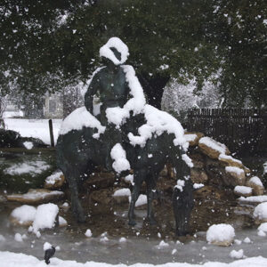 Picture of a cowboy statue covered in snow